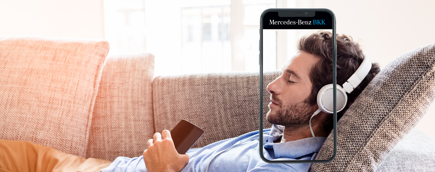 Ein Mann liegt auf einem Sofa umrahmt von einem Smartphone.