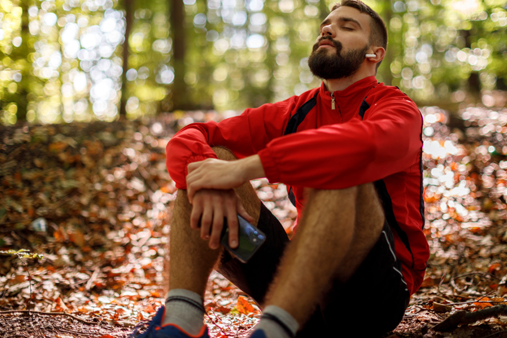 Ein Mann sitzt im Wald und meditiert.
