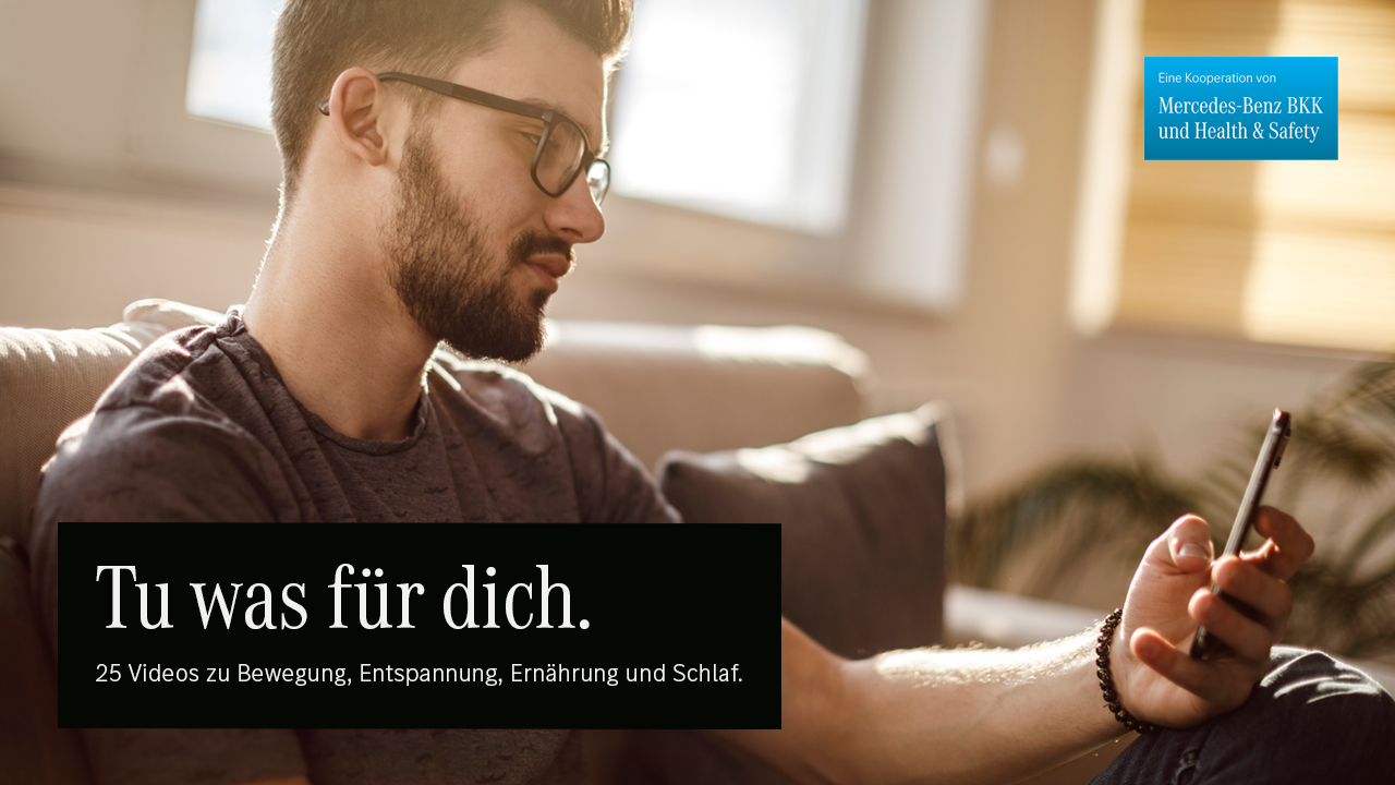 Ein junger Mann man schaut auf sein Smartphone.