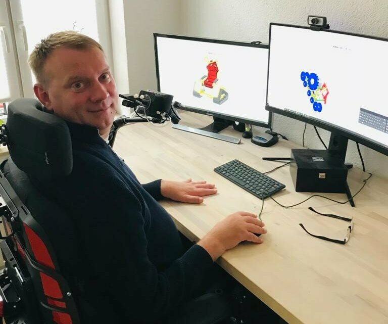 Ein Mann im Rollstuhl arbeitet am Computer
