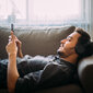 Ein Mann schaut auf sein Smartphone und chillt.