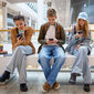 Mehrere Jugendliche schauen auf ihre Smartphones.