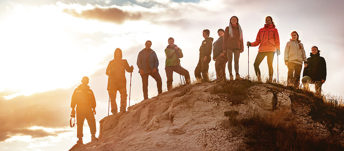 Eine Gruppe Menschen steht auf einem Berg.