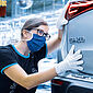 Eine Mitarbeiterin prüft einen Mercedes.